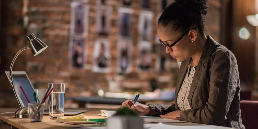 A woman working on papers at a desk