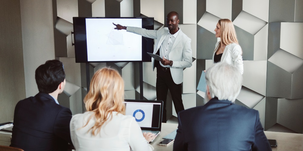 A man and woman giving a presentation in front of a small group of people