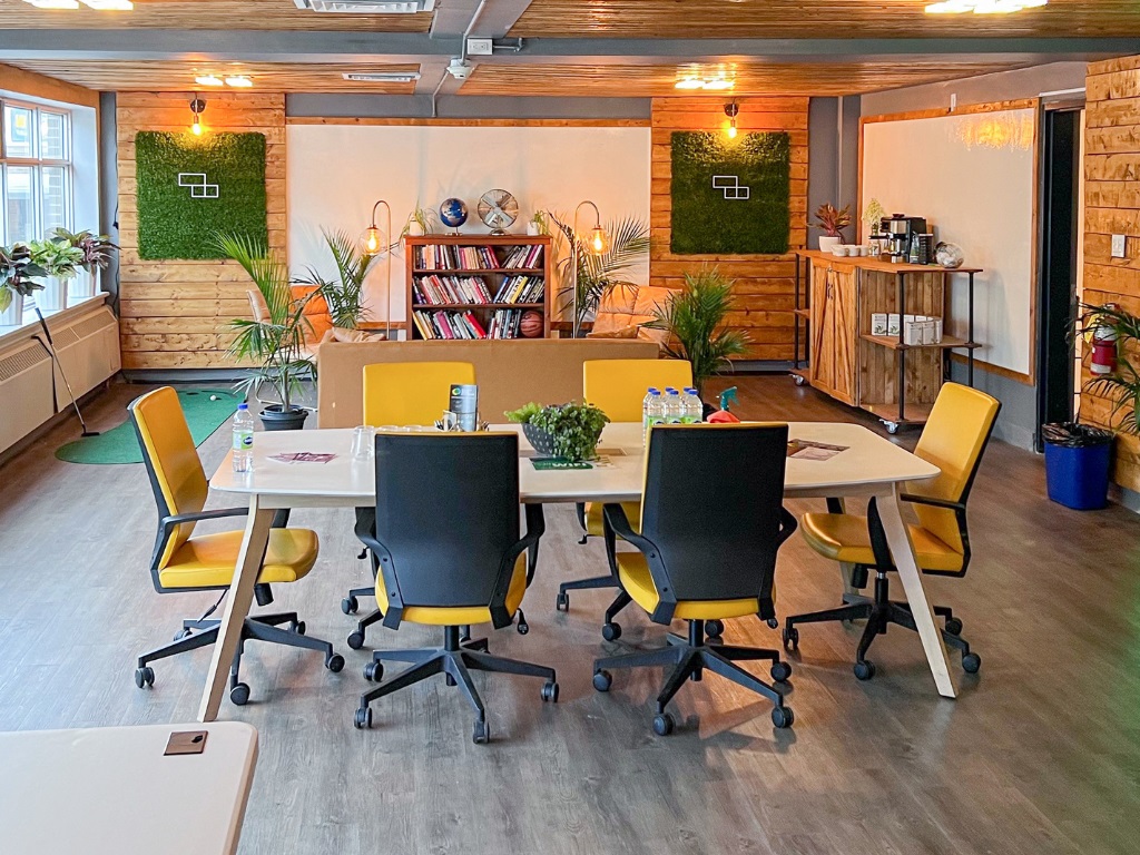 A table and six office chairs in the middle of a bright wood-panelled room