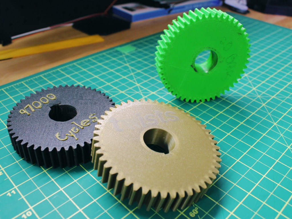 Three 3D printed gears on a cutting mat