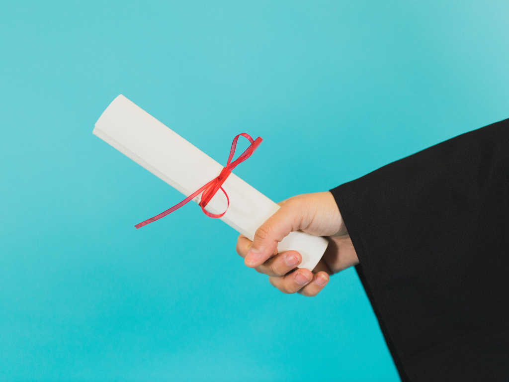 This is a picture of someone handing off a diploma for a graduation